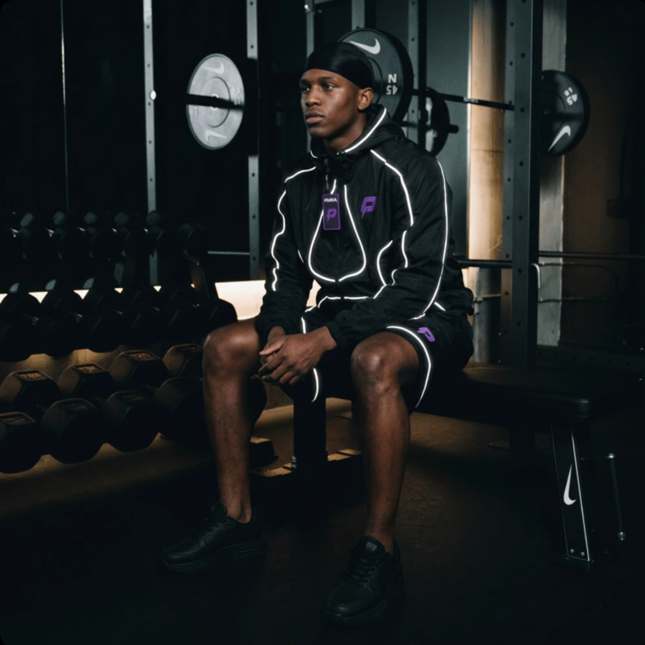 PURPL reflective tracksuit worn in a dark gym